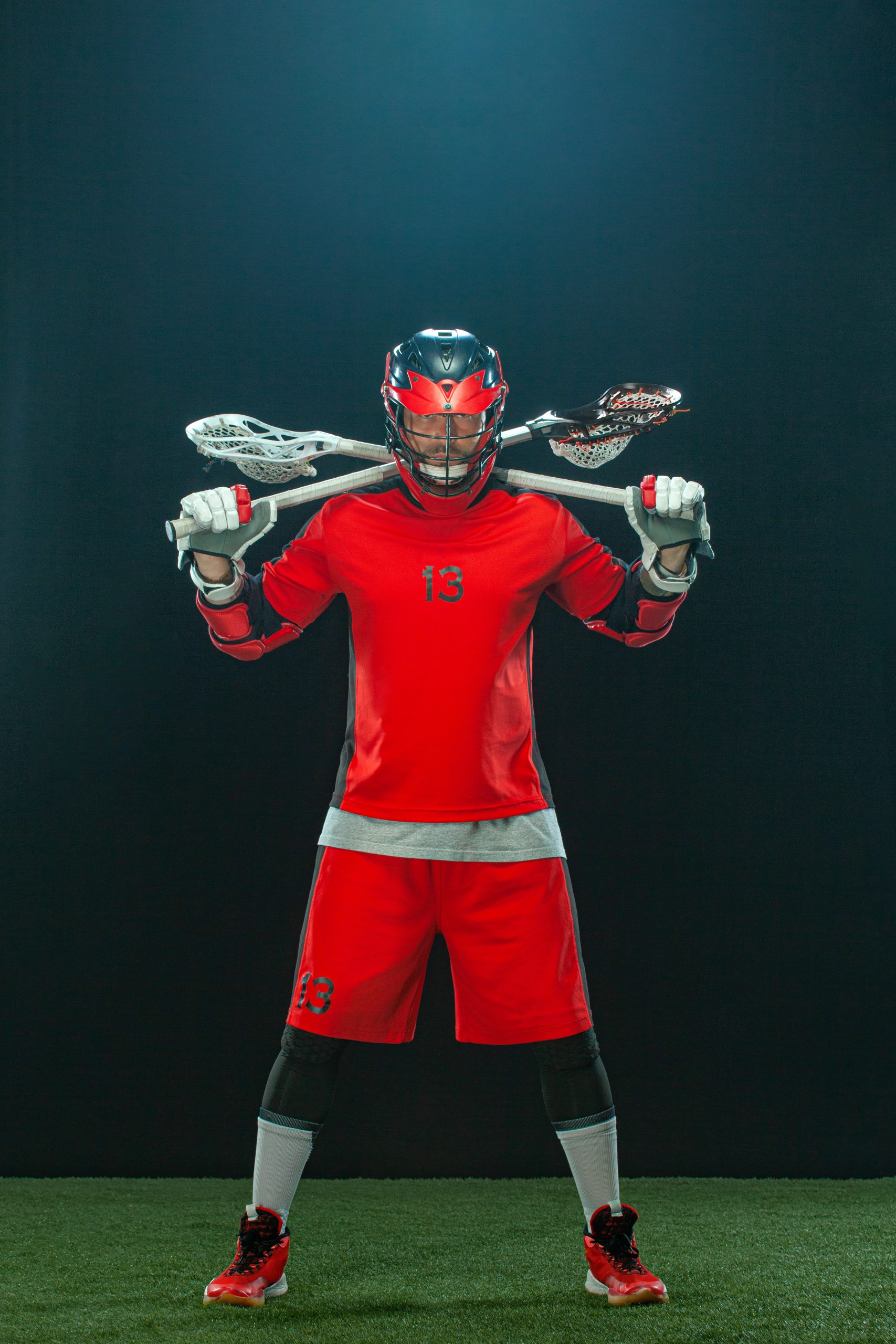 Lacrosse Player, athlete sportsman in red helmet on dark background. Sport and motivation wallpaper